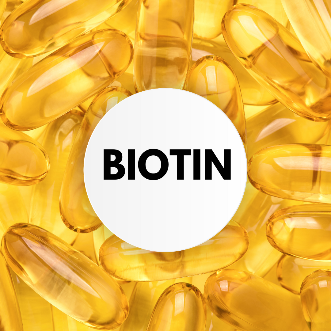 This image shows a close-up view of yellow biotin vitamins with the word "biotin" written in bold letters. The image represents the importance of biotin for healthy hair growth and how it can be obtained through supplementation or biotin-rich foods.